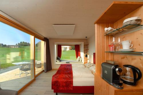 ein Schlafzimmer mit einem Bett und einem großen Fenster in der Unterkunft roo'n Lodges#KOLM in Arbesbach