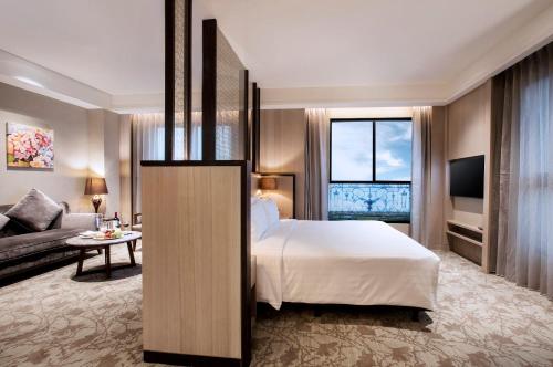 a hotel room with a bed and a couch at Hotel Valletta in Jiaoxi