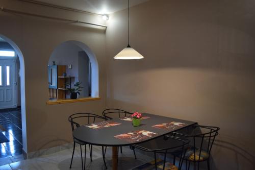 a dining room table with chairs and a vase of flowers on it at La Mia Casa Vendégház in Kaposvár