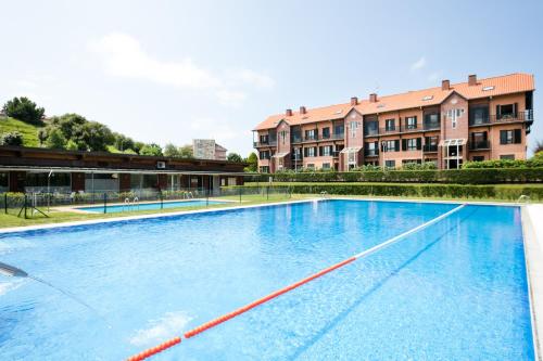an empty swimming pool in front of a building at Abba Comillas Apartments in Comillas