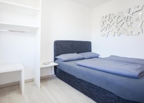 ein Schlafzimmer mit einem Bett, einem Schreibtisch und einer weißen Wand in der Unterkunft Stadtstreuner in Winterberg