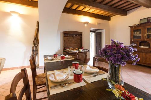a dining room with a table with a vase of flowers at Agriturismo L'Antico Frutto in Premilcuore
