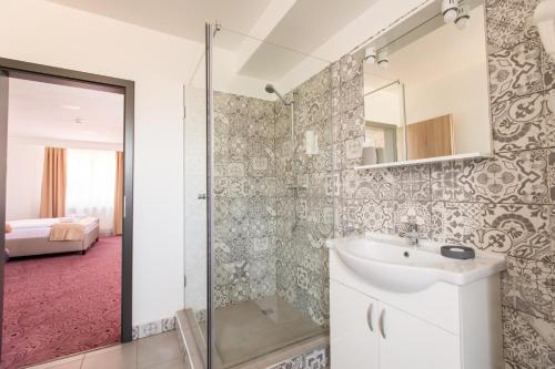 een badkamer met een wastafel en een douche bij Pensiunea Simar in Sibiu