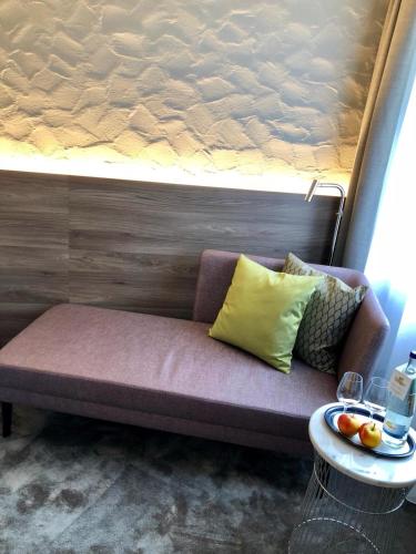a couch with pillows and a table in a room at Hotel Am Park in Leinfelden-Echterdingen