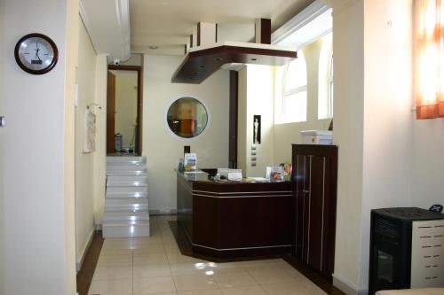 a hallway with a sink and a clock on the wall at Petit Palais Hotel in Loutraki