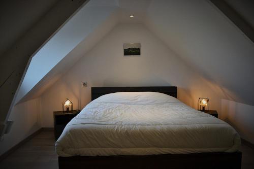 a bedroom with a white bed in a attic at Le Nid Des Grands Geais in Le Crotoy