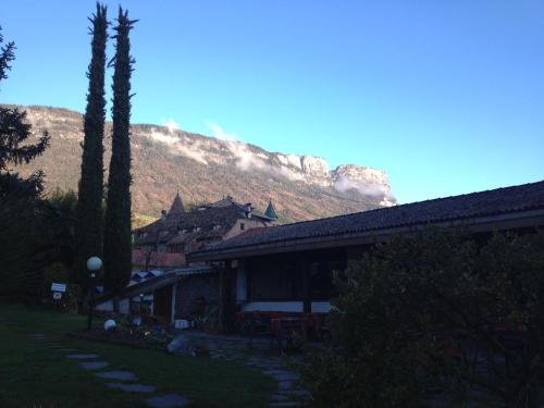 a house with a mountain in the background at Angerburg Blumenhotel in Appiano sulla Strada del Vino