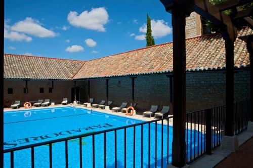 a swimming pool with chairs next to a building at Parador de Chinchón in Chinchón