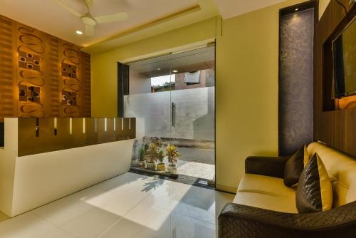 Hygienic Hotel Liberty Plaza في مومباي: غرفة معيشة بجدران صفراء وارضية زجاجية