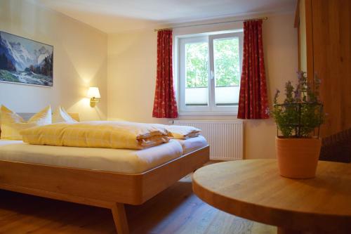a bedroom with a bed and a table and a window at Haus Partale in Oberstdorf