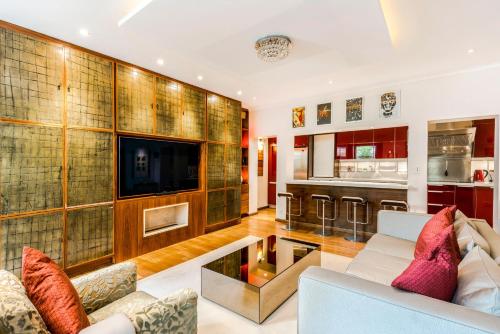 a living room with a couch and a tv at Garden Apartment London in London