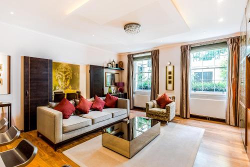 a living room with a couch and red pillows at Garden Apartment London in London