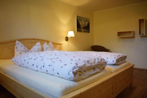 a bed with a white comforter and pillows on it at Haus Partale in Oberstdorf