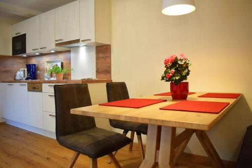 a kitchen with a wooden table with a vase of flowers on it at Haus Partale in Oberstdorf