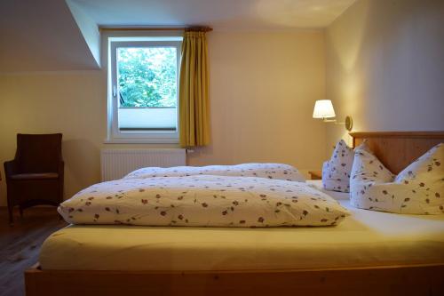 a bedroom with a bed with two pillows and a window at Haus Partale in Oberstdorf