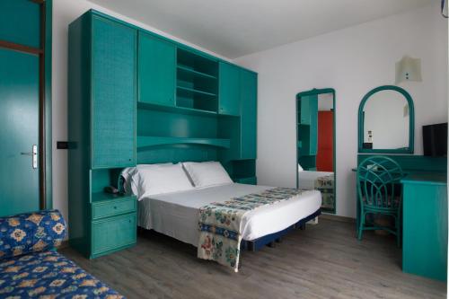a bedroom with a bed with a green headboard at Hotel Brioni Mare in Lido di Jesolo