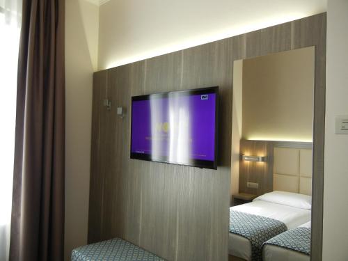 a flat screen tv on a wall in a hotel room at Delle Nazioni Milan Hotel in Milan