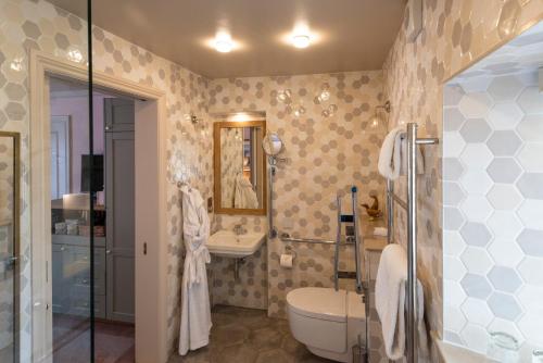a bathroom with a toilet and a sink and a tub at The Beeley Inn - Chatsworth in Beeley