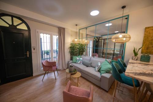 uma sala de estar com um sofá e algumas cadeiras em Cosy Apartment with Terrace in the Centre of Seville em Sevilha