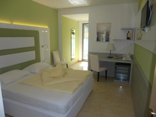 a bedroom with a bed and a desk in it at Beach Hotel Du Lac Malcesine in Malcesine