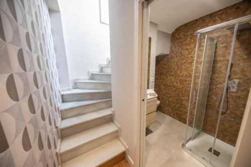 uma casa de banho com escadas e uma cabina de duche em vidro. em Cosy Apartment with Terrace in the Centre of Seville em Sevilha