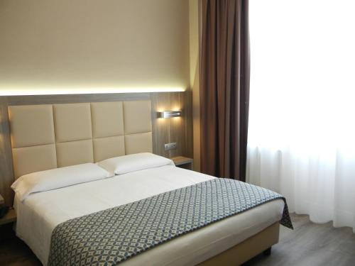 a bedroom with a bed and a large window at Delle Nazioni Milan Hotel in Milan