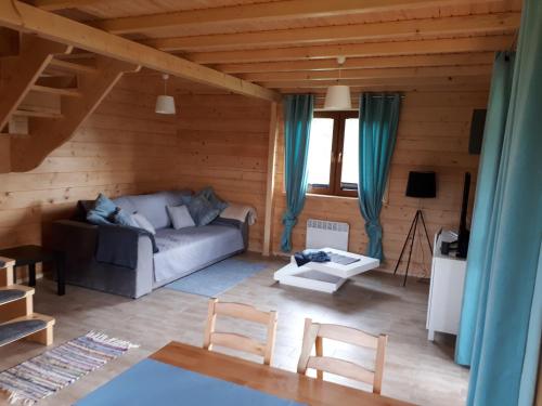 a living room with a couch and a table at Domek nad jeziorem Ublik in Miłki