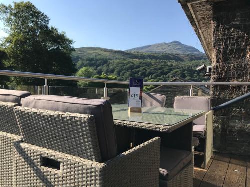 a table and chairs on a balcony with a view at Grapes Hotel, Bar & Restaurant Snowdonia Nr Zip World in Blaenau-Ffestiniog
