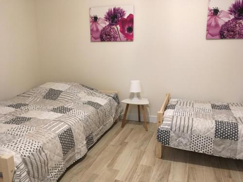 a bedroom with two beds and a table with a lamp at Ferienwohnung Mescherin 2 in Mescherin