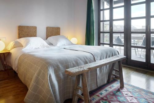 a bedroom with a bed with a bench next to a window at Nin de Beret 4 by FeelFree Rentals in Naut Aran