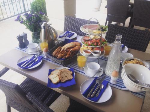 a table with breakfast foods and drinks on it at Guest House Villa Maslina Neum in Neum