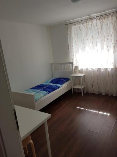 a small bedroom with a bed and a window at Gästehaus Ditz in Westoverledingen