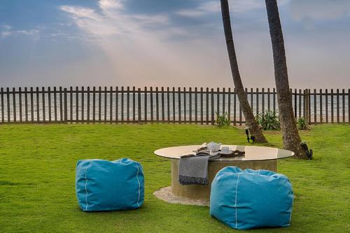 two blue chairs sitting around a table in a field at Jetwing Villa 700 in Bentota