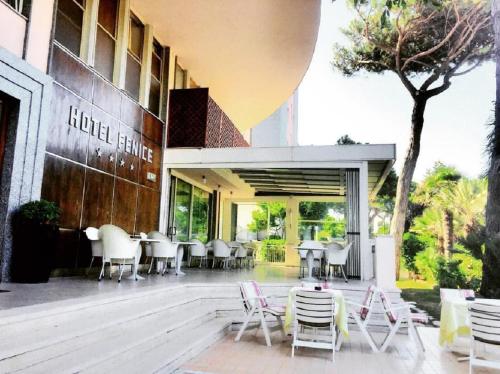 a restaurant with chairs and tables outside of a building at Hotel Fenice Gluten Free in Milano Marittima
