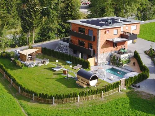 - une vue aérienne sur une maison avec une piscine dans l'établissement Chalet Appartement Antonhaus E-Ladestation, à Gaschurn