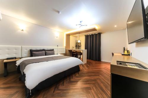 a hotel room with a large bed and a television at Busan Station BUSAN VIEW HOTEL in Busan