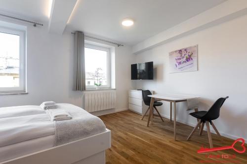 ein weißes Schlafzimmer mit einem Bett und einem Schreibtisch in der Unterkunft Apartment Nearto Old Town Sebastiana street in Krakau