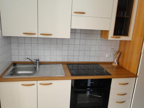 a kitchen with white cabinets and a sink at Zele in Dolac