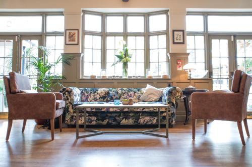 a living room with a couch and two chairs at The Fox & Goose Hotel in London
