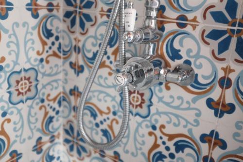 y baño con ducha y azulejos azules y blancos. en Casa Estilo Vintage en Cazorla, en Cazorla