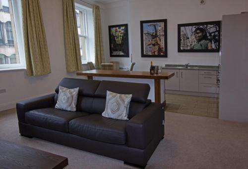 a living room with a couch and a kitchen at The Castle Collection 14 Cook Street in Liverpool