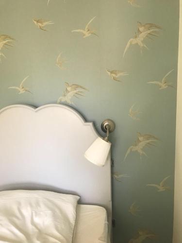 a bedroom with a wall with birds on the wall at Haus Madita in Breitnau