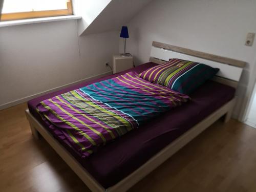 - un lit dans une chambre avec une couette violette dans l'établissement Villa Mahnberg, à Rödental