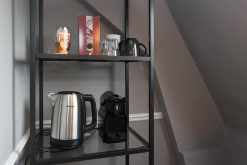 a metal shelf with a coffee maker on it at Westerpark Suites in Amsterdam