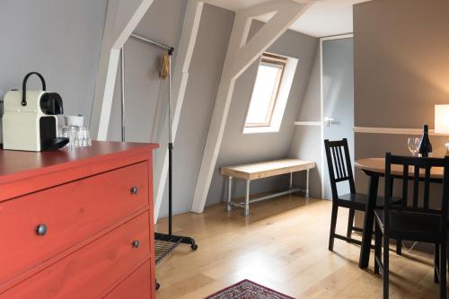 a room with a red dresser and a table and chair at Westerpark Suites in Amsterdam