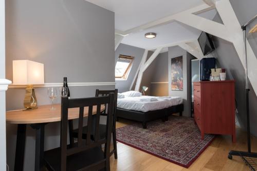 une chambre avec un lit et une table et une salle à manger dans l'établissement Westerpark Suites, à Amsterdam