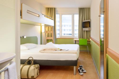 a hotel room with a bed and a desk at ibis budget Aachen City in Aachen