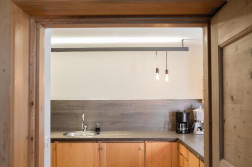 a kitchen with wooden cabinets and a sink at Chalet Hafling Zoila in Avelengo