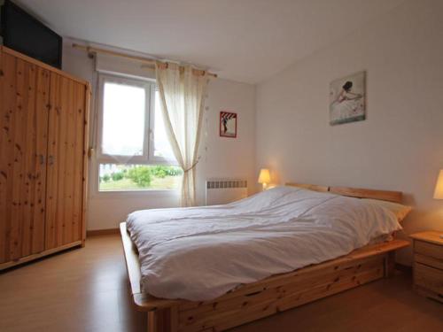 Un dormitorio con una cama grande y una ventana en résidence vallée des lacs, en Le Tholy
