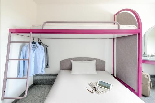 ein Schlafzimmer mit einem Etagenbett mit einem lila Etagenbett in der Unterkunft CREO Halle Peissen in Peißen